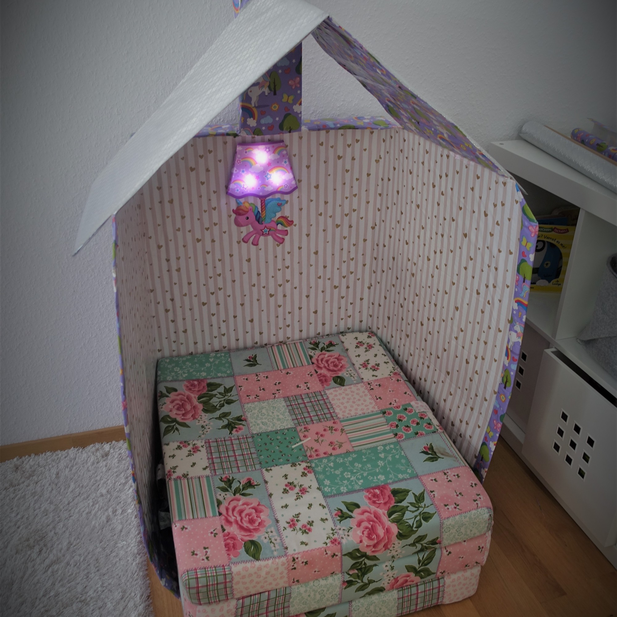 The final cardboard playhouse with a little lamp in the middle