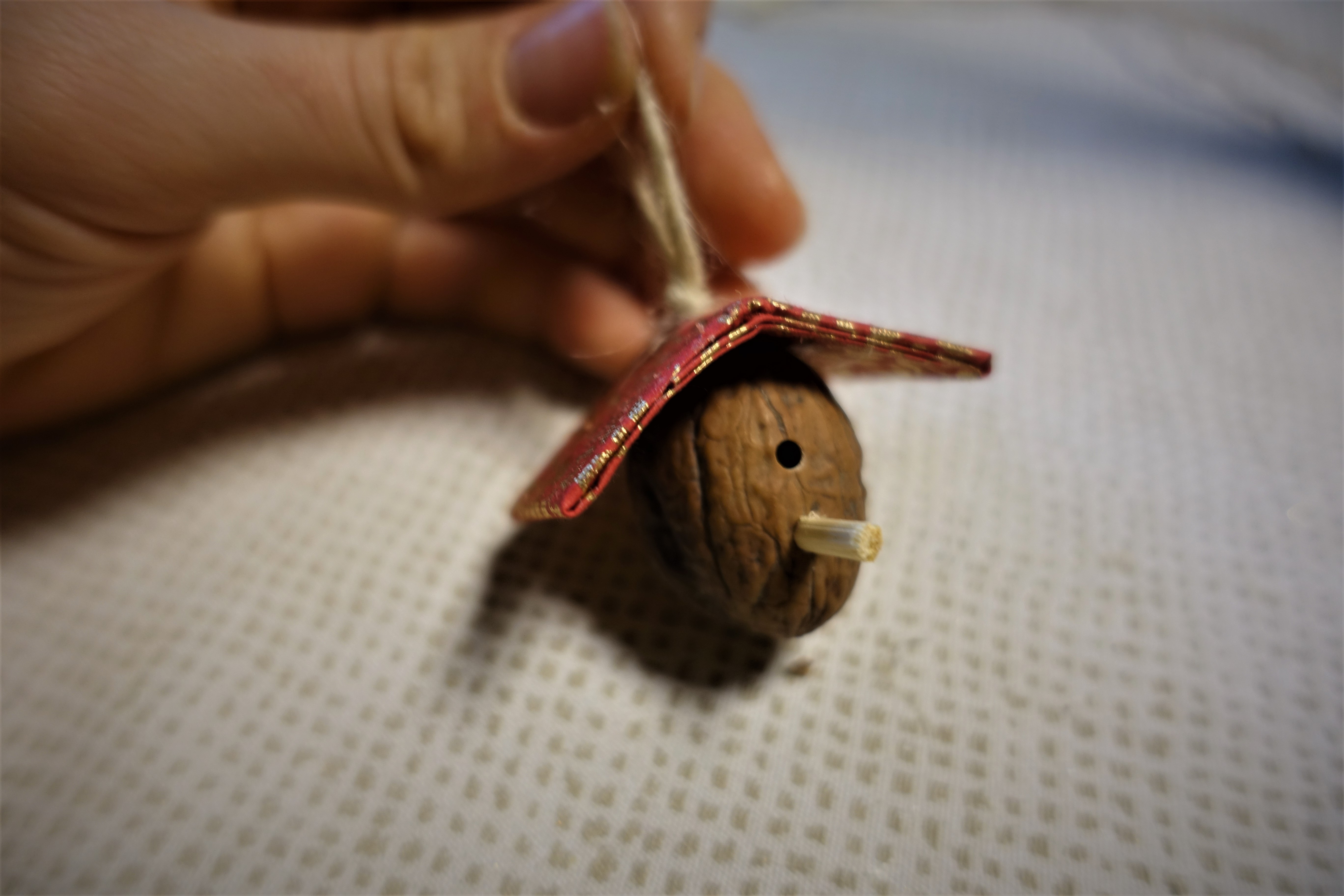 A bird house ornament made out of a walnut
