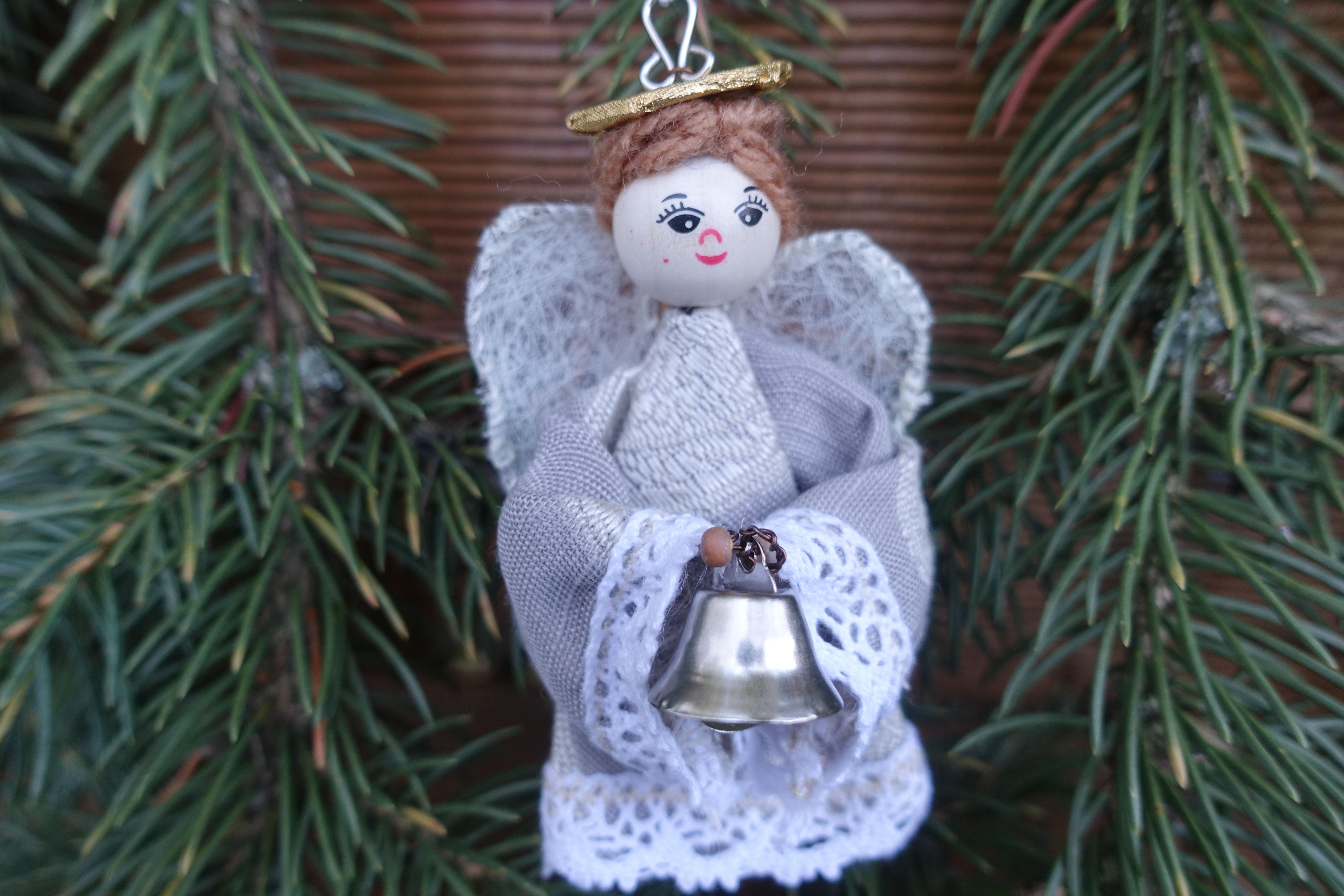 White angel ornament holding a miniature bell